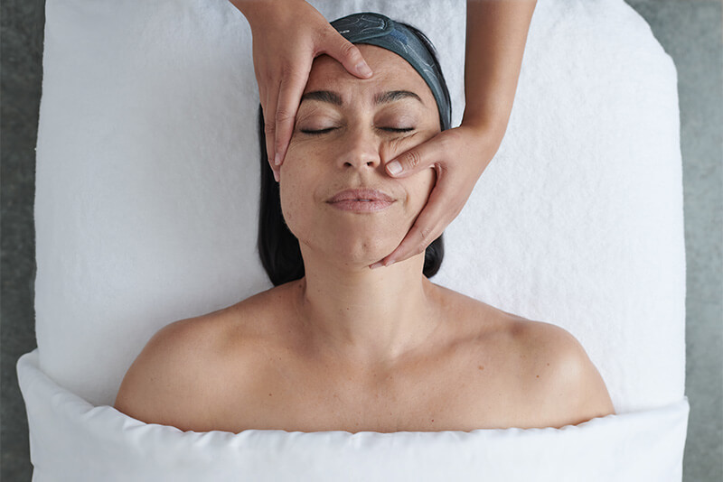 Kosmetik Harborg-Kundin genießt mit geschlossenen Augen eine entspannende Faszien-Massage.