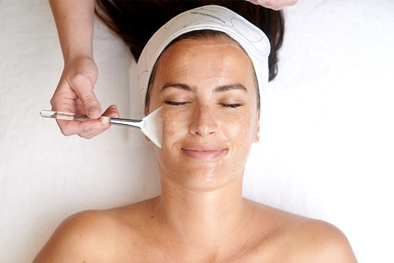 Frau mit geschlossenen Augen bekommt eine Dermalogica Pro Skin-Gesichtsbehandlung. Ihr Gesicht wird mit einem Pinsel berührt.