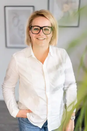 Dermalogica Expert Nadine Tenostendarp steht im Hautpflegestudio Harborg freundlich lächelnd.